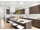 Bright, open kitchen features an island, stainless steel appliances, modern lighting, and dark wood cabinetry at 556 Monroe St, Denver, CO 80206