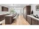 Sleek kitchen with dark wood cabinets, a long island with seating, and stainless steel appliances at 556 Monroe St, Denver, CO 80206