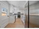 Well-lit kitchen featuring white cabinets, stainless steel appliances, and a door leading to the outside at 3738 N Eliot St # 2, Denver, CO 80211