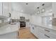 Spacious kitchen with white cabinets, stainless steel appliances, a central island, and sleek pendant lighting at 3738 N Eliot St # 2, Denver, CO 80211