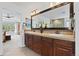 Bathroom featuring a double vanity with granite counters and a glimpse of the main bedroom at 11935 E Lake Ct, Greenwood Village, CO 80111