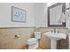Charming half-bathroom with a decorative mirror, pedestal sink, and beautiful wood floors at 11935 E Lake Ct, Greenwood Village, CO 80111