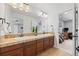 Bright bathroom with a double sink vanity and a large mirror that provides a full view of the interior at 11935 E Lake Ct, Greenwood Village, CO 80111