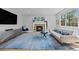 Living room with a brick fireplace, hardwood floors, a blue area rug and a grey couch at 11935 E Lake Ct, Greenwood Village, CO 80111
