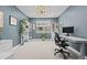 Cozy office with a large window, white bookshelves, an adjustable desk, and soft carpet at 11935 E Lake Ct, Greenwood Village, CO 80111