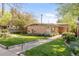 Charming mid-century home featuring a brick facade, mature trees, and a well-manicured lawn at 3242 4Th St, Boulder, CO 80304