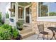 Charming front porch adorned with stone accents, potted plants, and a cozy seating area at 7 Shetland Ct, Highlands Ranch, CO 80130