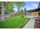 Fenced backyard features a lush lawn, mature trees and a covered patio, perfect for outdoor enjoyment and entertaining at 7659 S Holland Way, Littleton, CO 80128