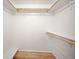 Walk-in closet with wood-look flooring and shelving, offering ample storage space in the basement at 7659 S Holland Way, Littleton, CO 80128