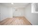 Finished basement featuring wood-look floors, a window, and fresh white walls, perfect for a flexible living space at 7659 S Holland Way, Littleton, CO 80128