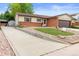 Exterior view of a charming ranch home with a long concrete driveway and front yard at 7659 S Holland Way, Littleton, CO 80128