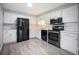 Well-equipped kitchen features white cabinets, black appliances, and updated flooring at 7659 S Holland Way, Littleton, CO 80128
