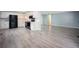 Open concept kitchen with white cabinetry, black appliances, and new laminate flooring at 7659 S Holland Way, Littleton, CO 80128