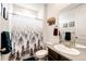 Well-lit bathroom featuring modern fixtures, a decorative shower curtain, and wood accents at 985 S Elk Way, Aurora, CO 80018