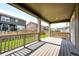 Back patio with wood deck, railings, and view of fenced yard at 985 S Elk Way, Aurora, CO 80018