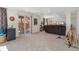 Finished basement with neutral carpet, sliding glass doors to outside patio, and mini fridge at 9230 W Indore Dr, Littleton, CO 80128