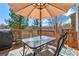 Outdoor deck featuring a patio table and chairs with an umbrella for shade at 9230 W Indore Dr, Littleton, CO 80128