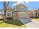 Charming two-story home with a well-maintained lawn and a two-car garage at 9230 W Indore Dr, Littleton, CO 80128