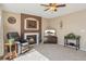 Bright living room featuring a fireplace with tile surround, comfortable seating, and a ceiling fan at 9230 W Indore Dr, Littleton, CO 80128
