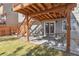 Covered patio area with table and chairs, with grass and steps leading up to the deck at 9230 W Indore Dr, Littleton, CO 80128