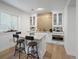 Stylish home bar area with white cabinetry, a marble countertop island and seating for two at 9035 S Shawnee Ct, Aurora, CO 80016