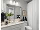 Clean bathroom features a white vanity with modern fixtures, white countertop, and artwork at 9035 S Shawnee Ct, Aurora, CO 80016