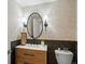 Stylish powder room featuring patterned wallpaper, modern fixtures, and a wood-paneled accent wall at 9035 S Shawnee Ct, Aurora, CO 80016