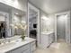 Bright bathroom features a double vanity, tile floors, and glass-enclosed shower at 9035 S Shawnee Ct, Aurora, CO 80016