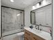 Modern bathroom featuring a black framed shower, wood vanity, and matte black fixtures at 9035 S Shawnee Ct, Aurora, CO 80016