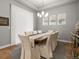 Bright dining room featuring a wooden table, elegant chandelier, and neutral decor at 9035 S Shawnee Ct, Aurora, CO 80016