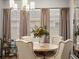 Bright dining area featuring a round table, upholstered chairs, and large windows with stylish neutral colored drapes at 9035 S Shawnee Ct, Aurora, CO 80016