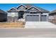 Charming two-story home showcasing a three car garage and stone accents at 9035 S Shawnee Ct, Aurora, CO 80016