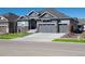 Charming home with gray siding, stone accents, well-manicured lawn and a three-car garage at 9035 S Shawnee Ct, Aurora, CO 80016