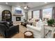 Bright and airy living room featuring a beautiful stone fireplace and large windows at 9035 S Shawnee Ct, Aurora, CO 80016