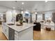 Open concept: kitchen island flows into living room with fireplace feature at 9035 S Shawnee Ct, Aurora, CO 80016