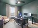 Stylish home office featuring a dark green walls, desk, and a comfortable chair by the window at 9035 S Shawnee Ct, Aurora, CO 80016