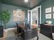 Cozy home office featuring dark green walls, white trim, and an adjacent sitting area at 9035 S Shawnee Ct, Aurora, CO 80016