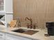Wet bar with a bronze faucet, undermount sink, tile backsplash, and white cabinets at 9035 S Shawnee Ct, Aurora, CO 80016