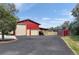 The barn features two garage doors, additional covered storage and a shed, all set against a bright blue sky at 20155 E Davies Ave, Centennial, CO 80016