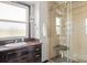 Bathroom featuring dark wood vanity, sink, granite counters, a window, and a glass enclosed shower at 20155 E Davies Ave, Centennial, CO 80016