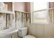 Small bathroom showing a white sink, toilet, window, and walls with distressed paint at 20155 E Davies Ave, Centennial, CO 80016