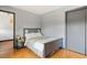 A bedroom with a grey bed with a white and gold quilt, a grey nightstand, and a closet at 20155 E Davies Ave, Centennial, CO 80016