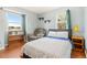 Bedroom with white textured comforter, blue sheet, two windows, a bookshelf and recliner at 20155 E Davies Ave, Centennial, CO 80016