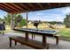 Inviting covered patio showcasing a large wooden table, bench, and scenic backyard views at 20155 E Davies Ave, Centennial, CO 80016