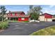 View of two-story red home featuring mature landscaping and a spacious driveway at 20155 E Davies Ave, Centennial, CO 80016