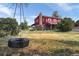 View of the two-story home exterior, with a tire swing hanging from a tree, and a partial view of the front yard at 20155 E Davies Ave, Centennial, CO 80016