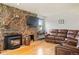 Cozy living room with stone fireplace, hardwood floors, and leather sofa at 20155 E Davies Ave, Centennial, CO 80016