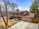 Inviting home featuring a large driveway, brick accents, mature trees, and well-kept landscaping at 7197 S Newland St, Littleton, CO 80128