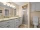 Well-lit bathroom featuring granite countertops, a framed mirror, and a glass-enclosed shower stall at 7197 S Newland St, Littleton, CO 80128