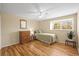 Sunlit bedroom showcases hardwood floors, neutral walls, a comfortable bed, and a window with a view of the outdoors at 7197 S Newland St, Littleton, CO 80128